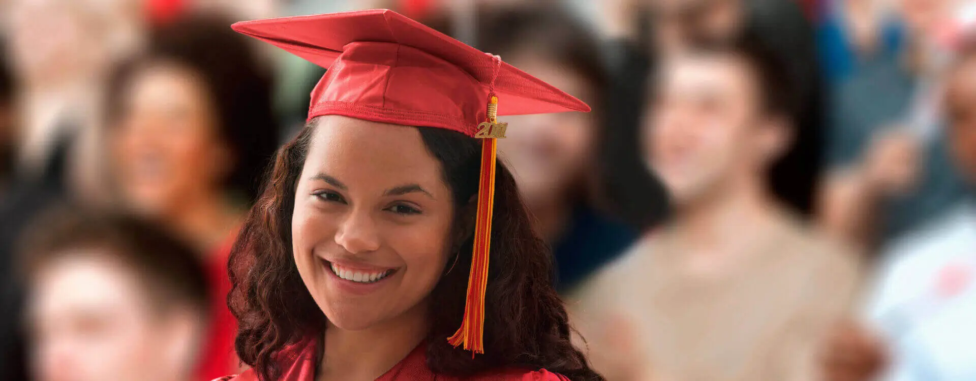 Person smiling as they graduate from a post-secondary institute.