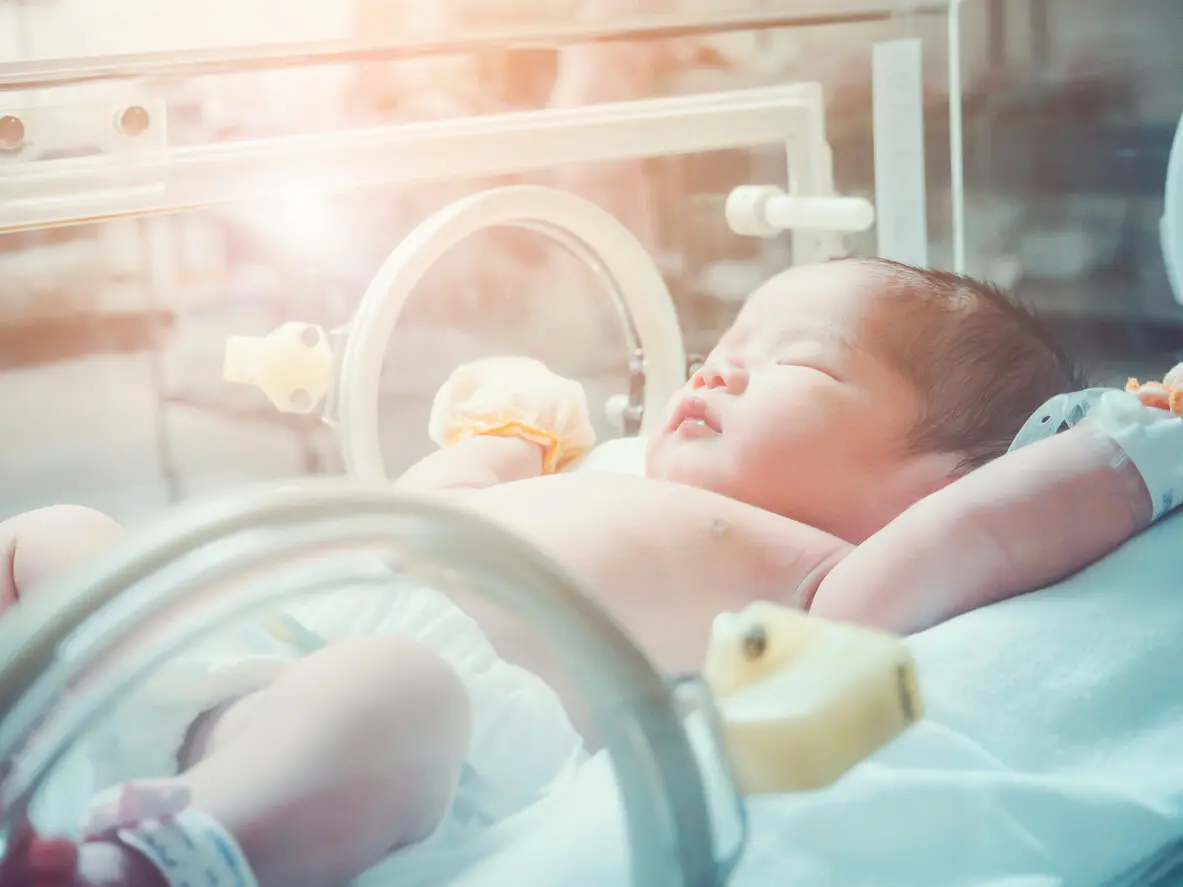 Newborn baby girl inside incubator in the NICU