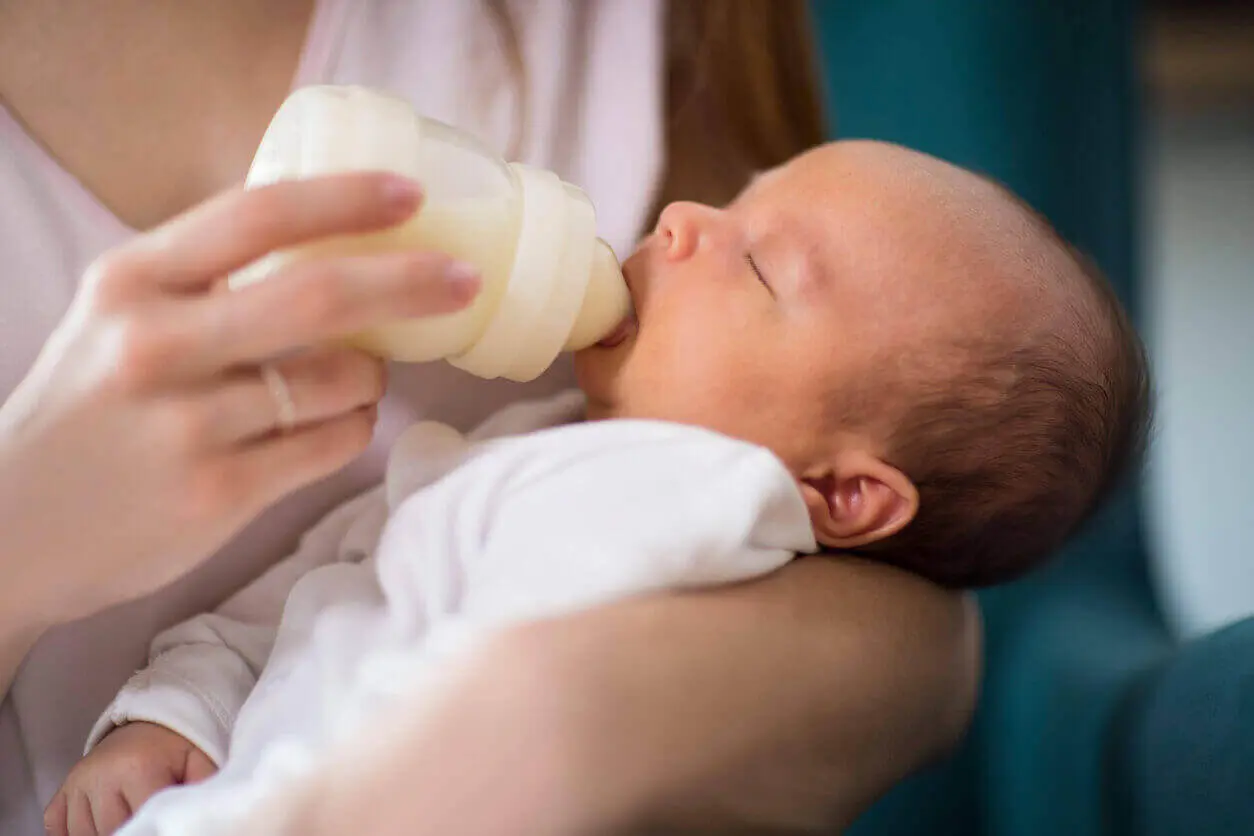 Close up of a female feeding a premature infant formula from a bottle