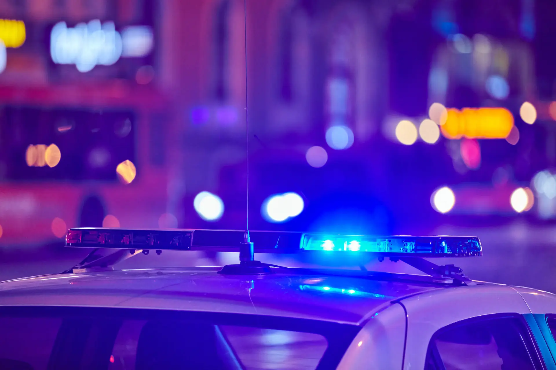 police car with blue siren light on pulling over an impaired driver