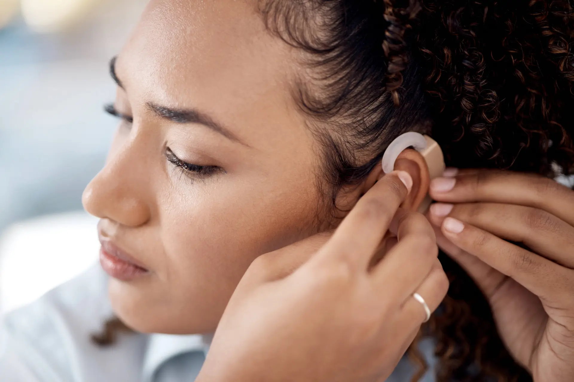 a person adjusts their cochlear implant to fit better on their ear