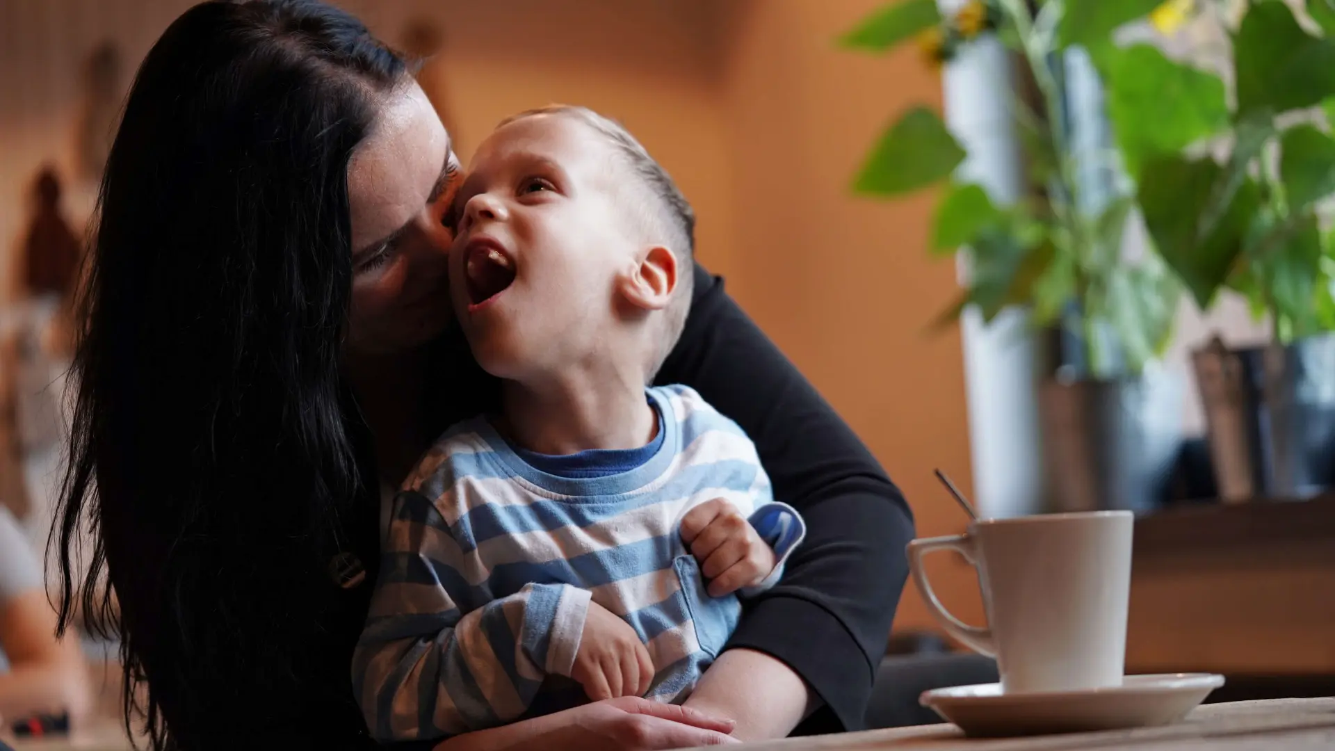 a woman cuddles with her child who has a neurodiversity