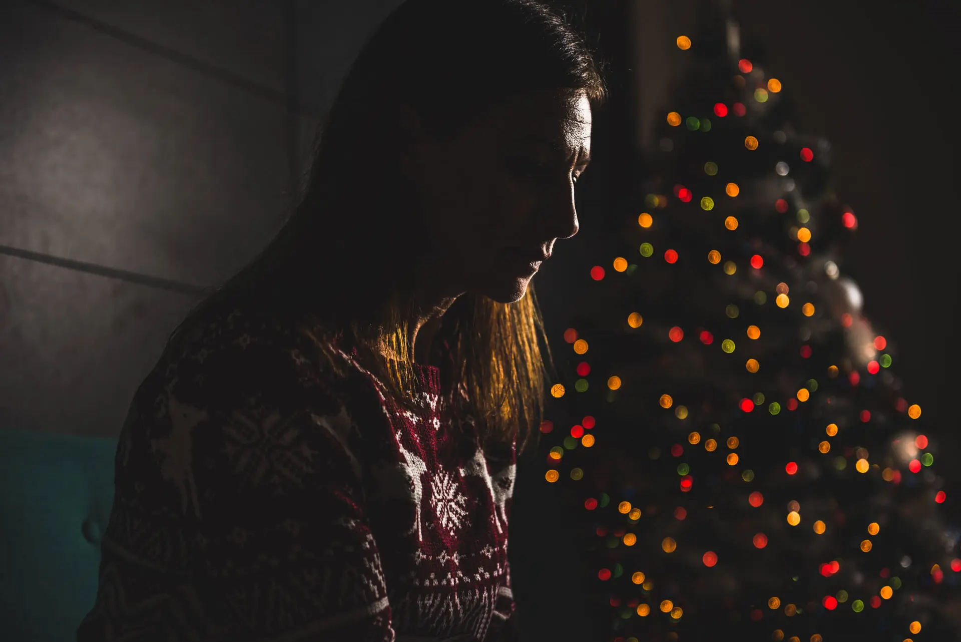 childhood abuse survivor sitting next to a christmas tree