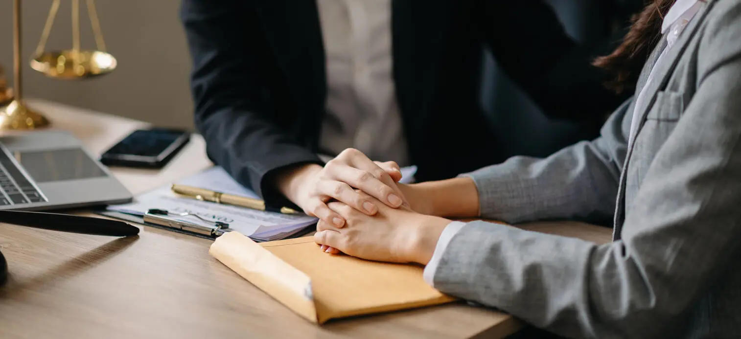a personal injury lawyer comforts their client in an office setting during a meeting
