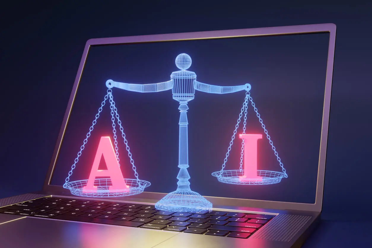 Scales of justice holding AI on a silver laptop