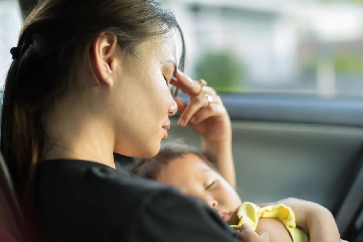 Concerned mother holding her sick baby