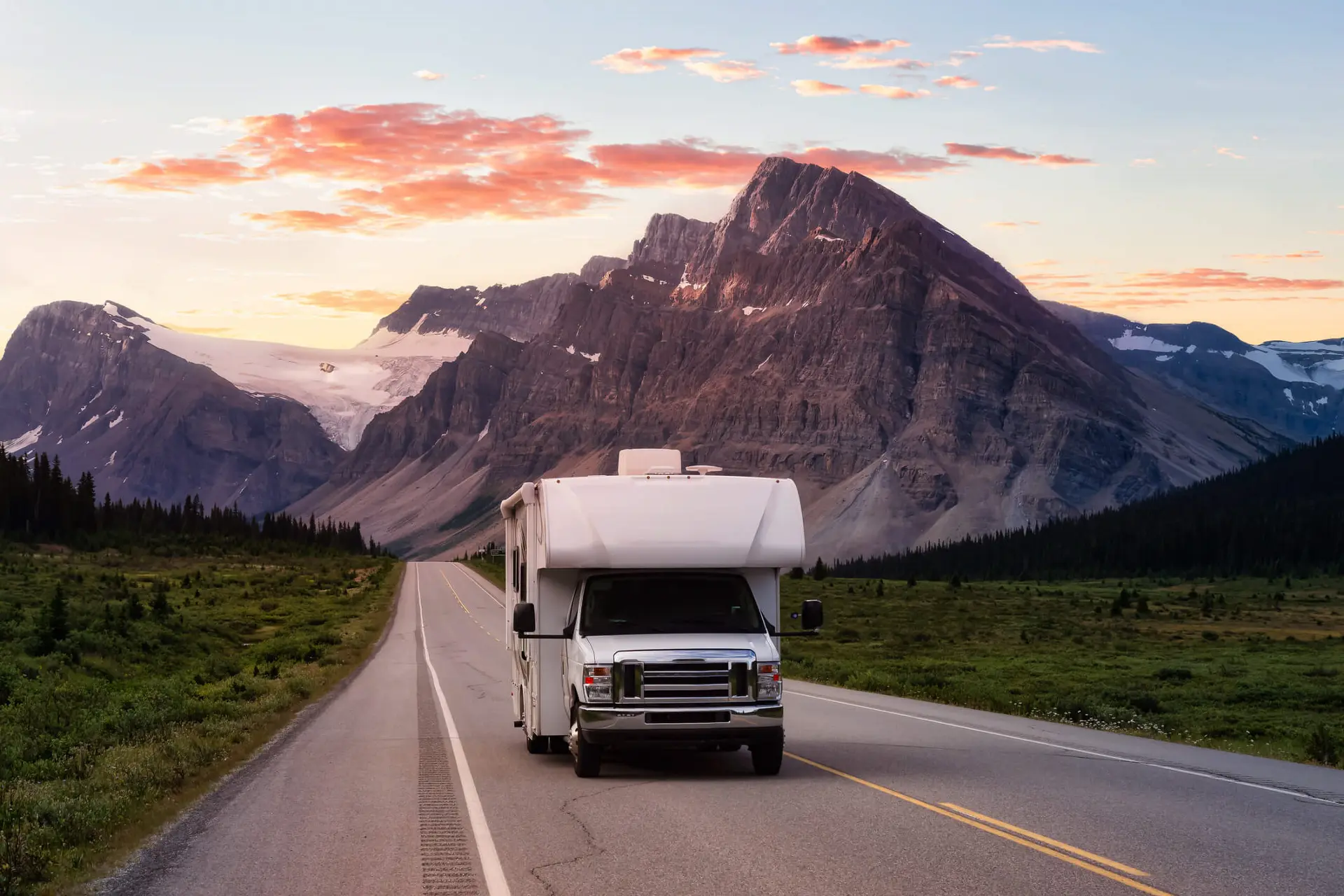 a family on a summer roadtrip drives through the Canadian rockies in an RV