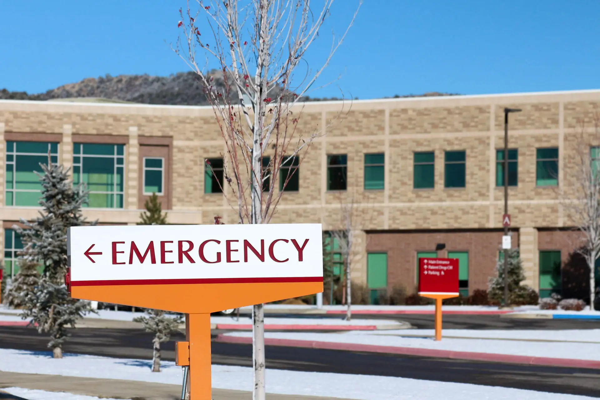 emergency room signage in front of a hospital on a snowy winter day during the holiday season
