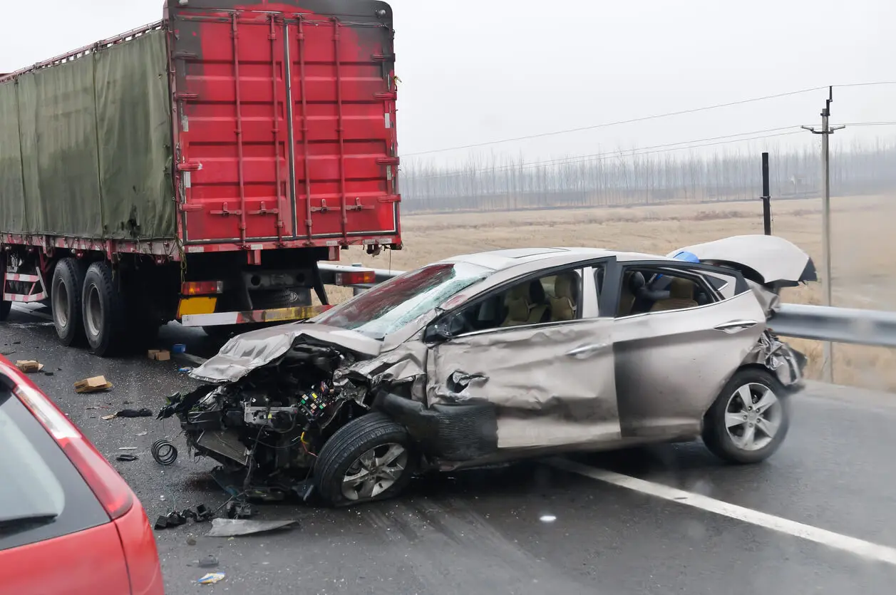 silver car totalled after truck accident on highway