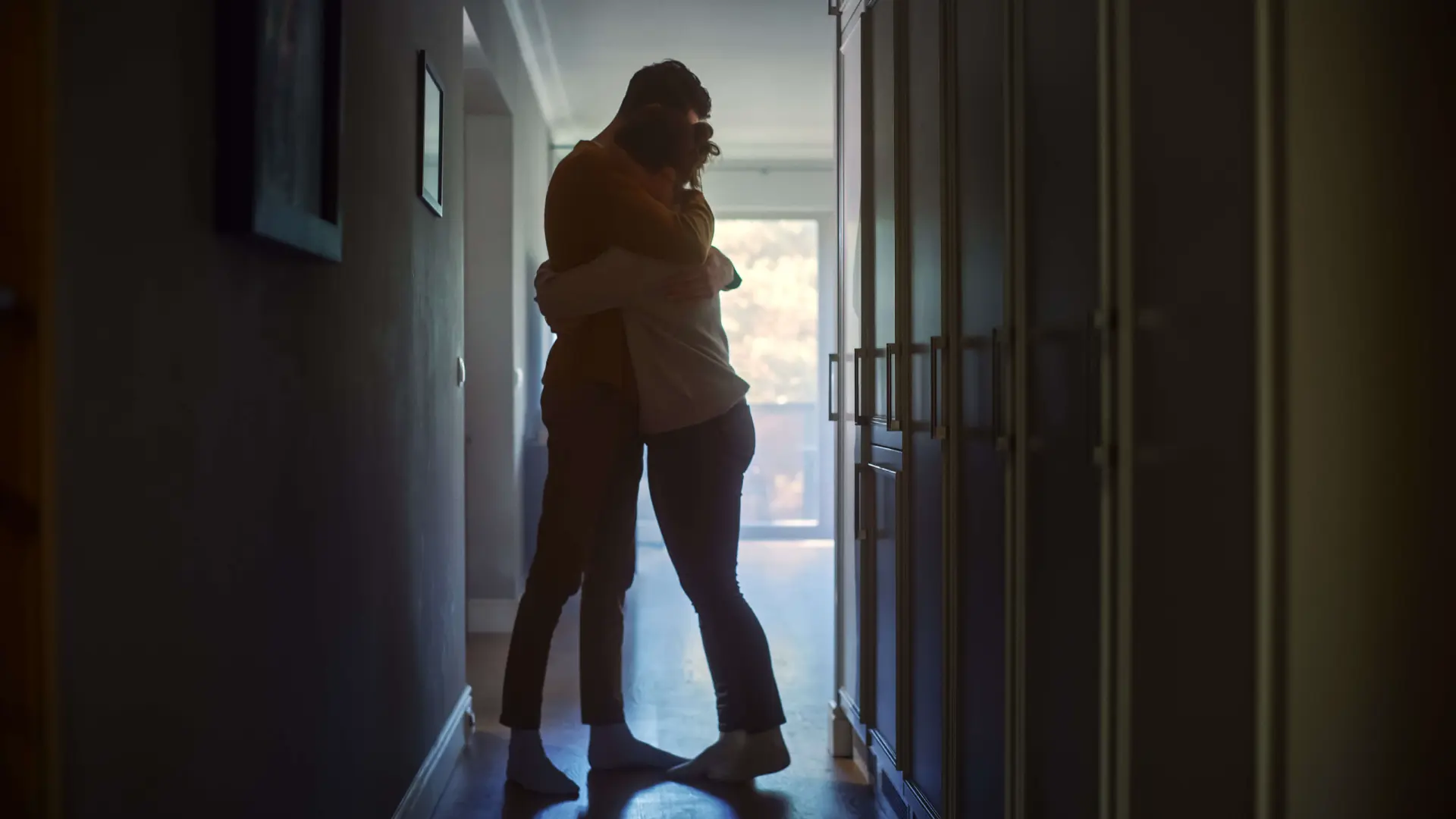 two people embrace in dark hallway as they contemplate what their options are after someone they loved suffered a wrongful death