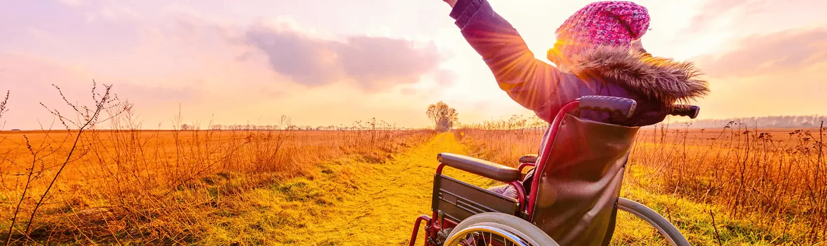 Child in wheelchair with arms up in a field Child in wheelchair with arms up in a field