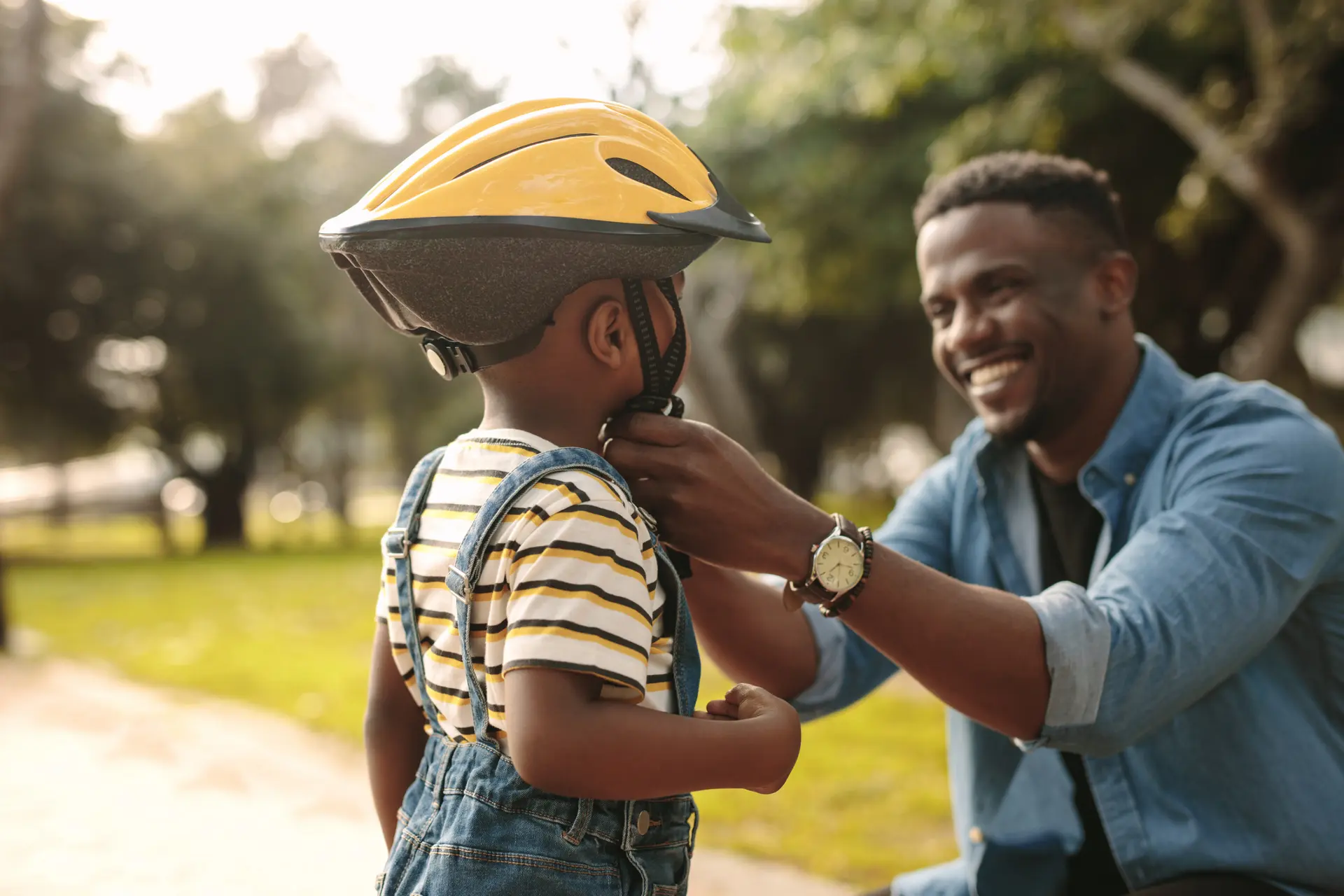 Father fastens bike helmet on his son