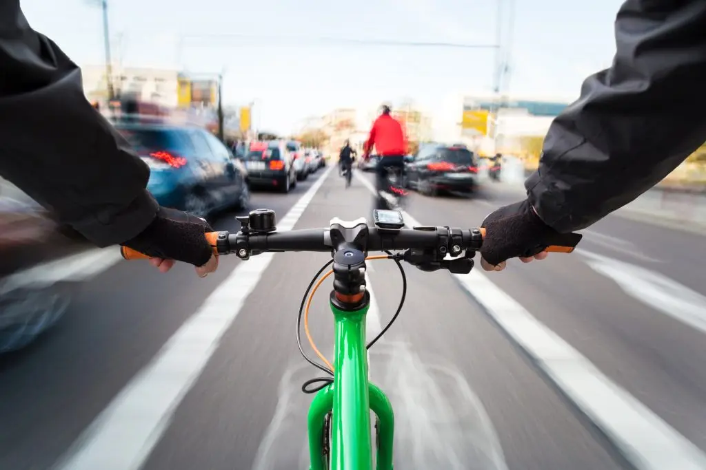 Cyclist drives on the bike path past the traffic jam - First-person view of cyclist/ motion blur stock photo