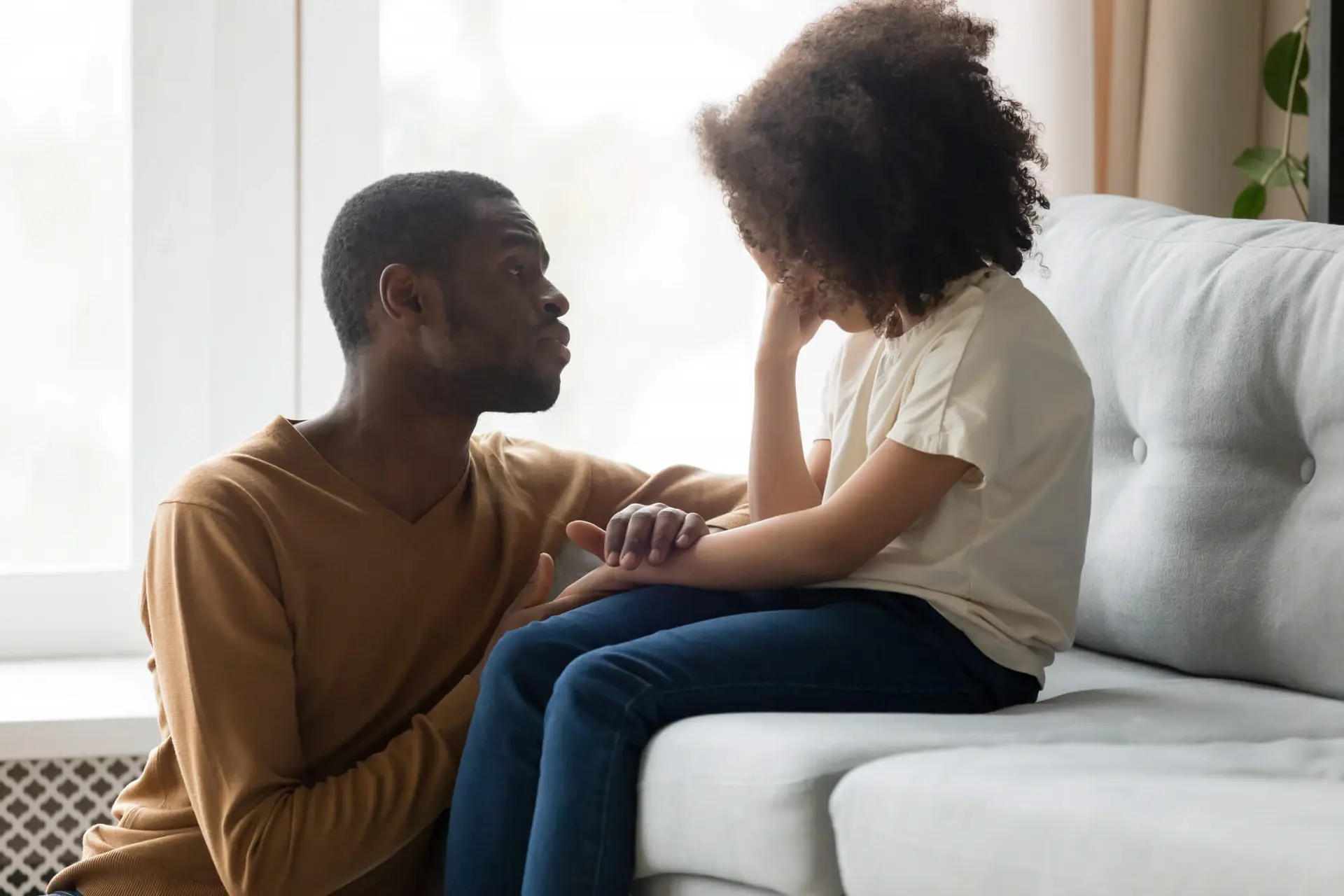 Loving African dad comforting daughter showing empathy stock photo