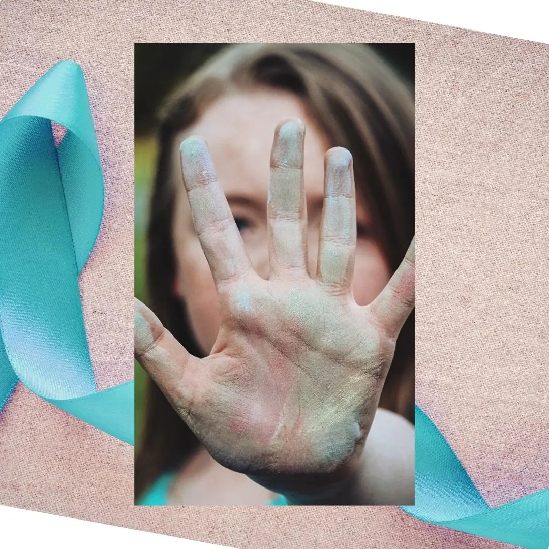 Teal Ribbon Sexual Assault Awareness and close up of female hand with blue chalk and blurred female face in background