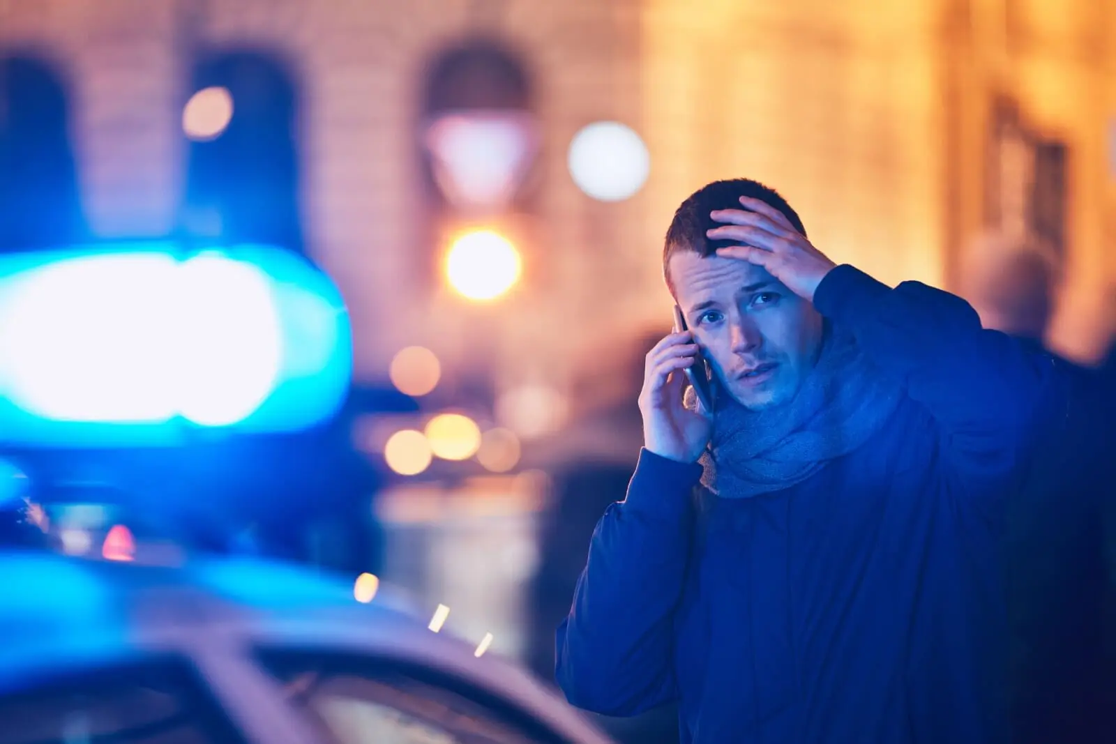 Distressed man making a phone call at the scene of a crime